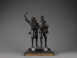 bronze statue of two men standing next to each other on a wooden base