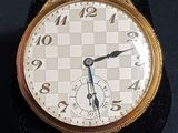 gros plan d'une montre en or sur une surface noire