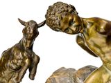 bronze statue of a boy and a goat on a rock