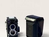 two old cameras sitting next to each other on a white surface