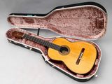une guitare dans un étui, posée sur une table