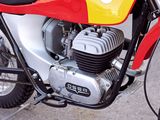 a red and yellow motorcycle parked on the side of the road