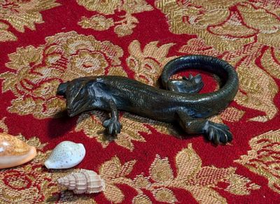 une photo d'une figurine de lézard posée sur un tapis rouge