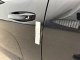 a close up of a car door handle with a sticker on it