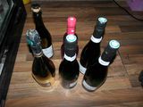 several bottles of wine are lined up on a wooden table