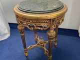 a small table with a marble top on a blue carpet