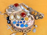 une boîte en bois sur laquelle est posé un assortiment de bijoux