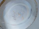 a close up of a white vase with a gold rim