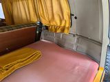 a bed in the back of a van with yellow curtains