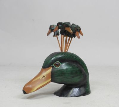 a wooden duck head with a bunch of birds on it