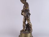 a bronze statue of a boy with a dog on a pedestal