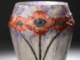 un vase en verre orné de fleurs peintes, posé sur une table