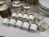 a lot of white and gold china on a table