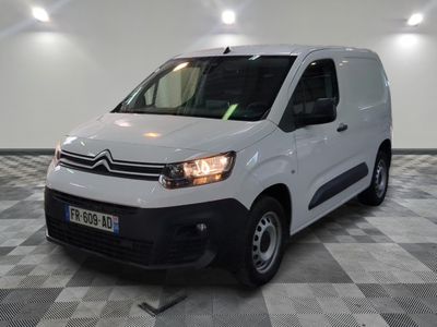 la camionnette blanche est garée sur un sol en damier dans le garage