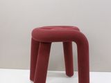 a small red stool sitting on a white surface
