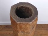 a wooden vase sitting on a wooden floor in a room