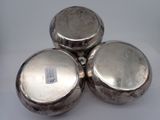 three silver pots sitting on top of each other on a white surface