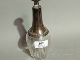 a small glass bottle with a silver lid on a table