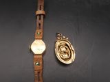 une image représentant une montre en or et une médaille en or sur un fond noir