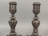 deux bougeoirs en argent posés sur une table
