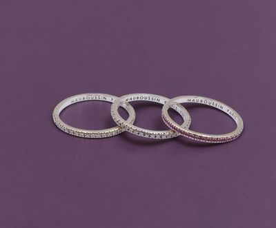trois bagues en argent portant des inscriptions, sur fond violet