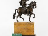 an antique bronze statue of a man on a horse on a marble base