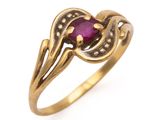 a close up of a gold ring with a ruby stone