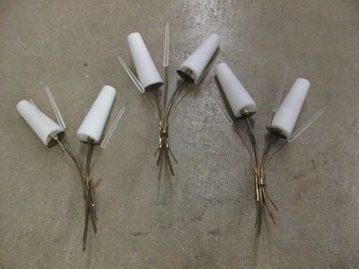 cinq vases blancs posés sur une table, avec une paire de ciseaux à côté
