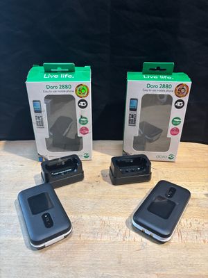 three cell phones sitting on top of a wooden table next to a box