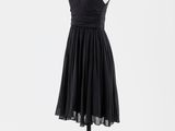 une robe noire posée sur un mannequin, sur fond blanc