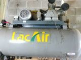 a tank with a compressor attached to it in a garage