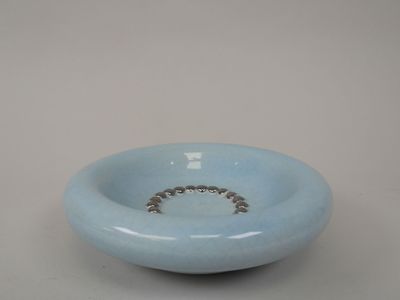 un bol bleu orné d'un anneau, posé sur une table