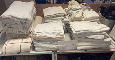 plusieurs piles de serviettes blanches pliées sur une étagère dans un magasin