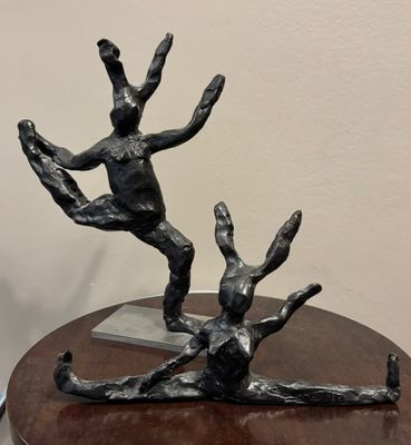 une sculpture en bronze représentant un homme et une femme, posée sur une table