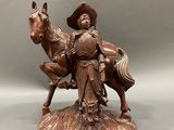 bronze statue of a man on a horse with a hat on
