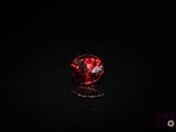 a close up of a red diamond on a black surface