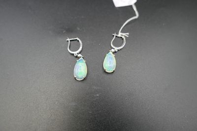 a pair of oplite earrings on a black surface