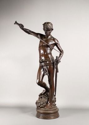 une statue en bronze représentant un homme tenant une épée et debout sur un rocher