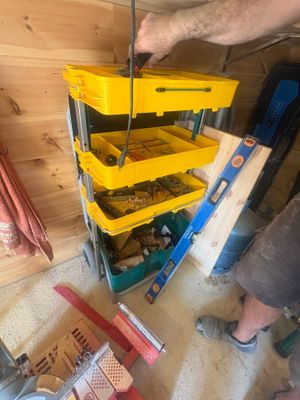 a man that is standing next to a cart with a bunch of tools