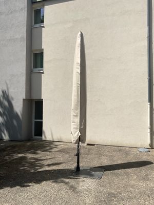 un grand parapluie fixé à un mât devant un immeuble