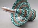 pair of green and white vases with designs on them on a white surface