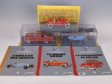 four toy cars in a display case on a table