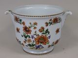 un vase blanc orné de fleurs orange et bleues