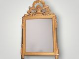 an image of a gold framed mirror on a white wall