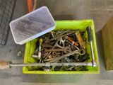 a green container filled with lots of screws and wrenches