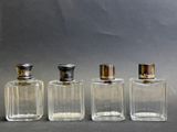 trois flacons de parfum sont alignés sur une surface grise