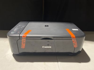 une imprimante Canon posée sur un comptoir près d'un mur