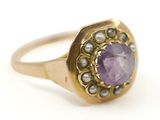 une image représentant une bague en or sertie d'une pierre violette et entourée de perles