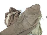 a pile of clothes sitting on the ground next to a car