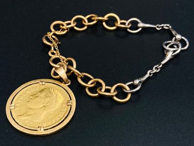 un gros plan d'un bracelet à maillons orné d'une pièce de monnaie